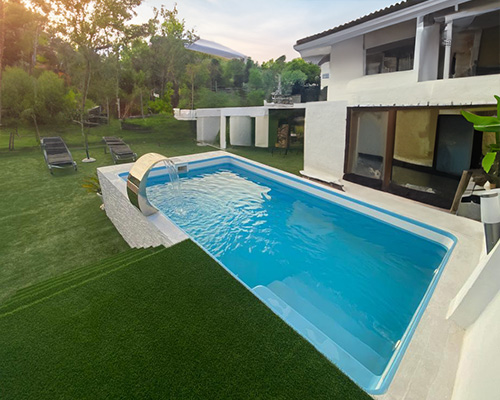 piscina rectangular prefabricada de fibra con escalera de poliester en jardin con encanto