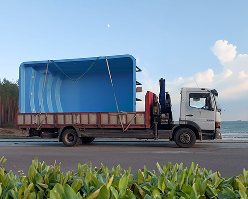 transporte piscina prefabricada Bahamas de poliester en camion con grua para descarga